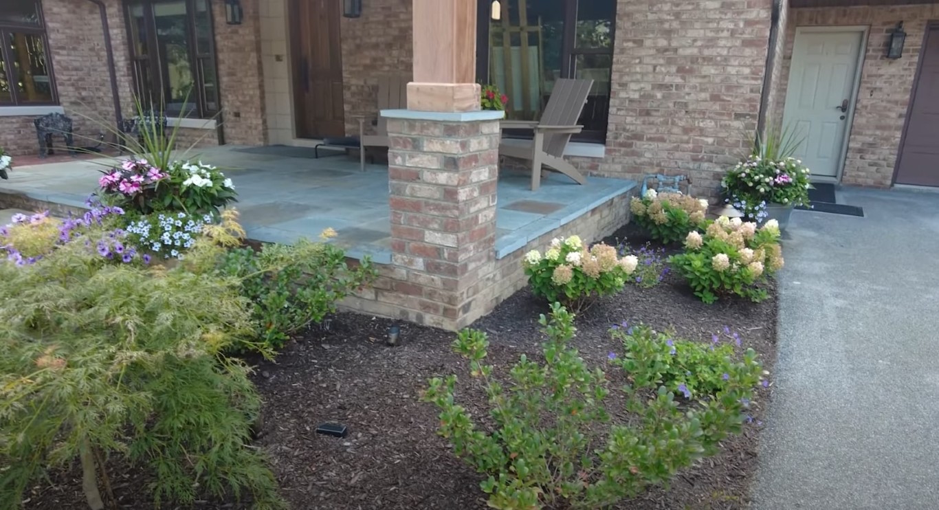 Hardscaping patio with outdoor seating and landscaped garden beds